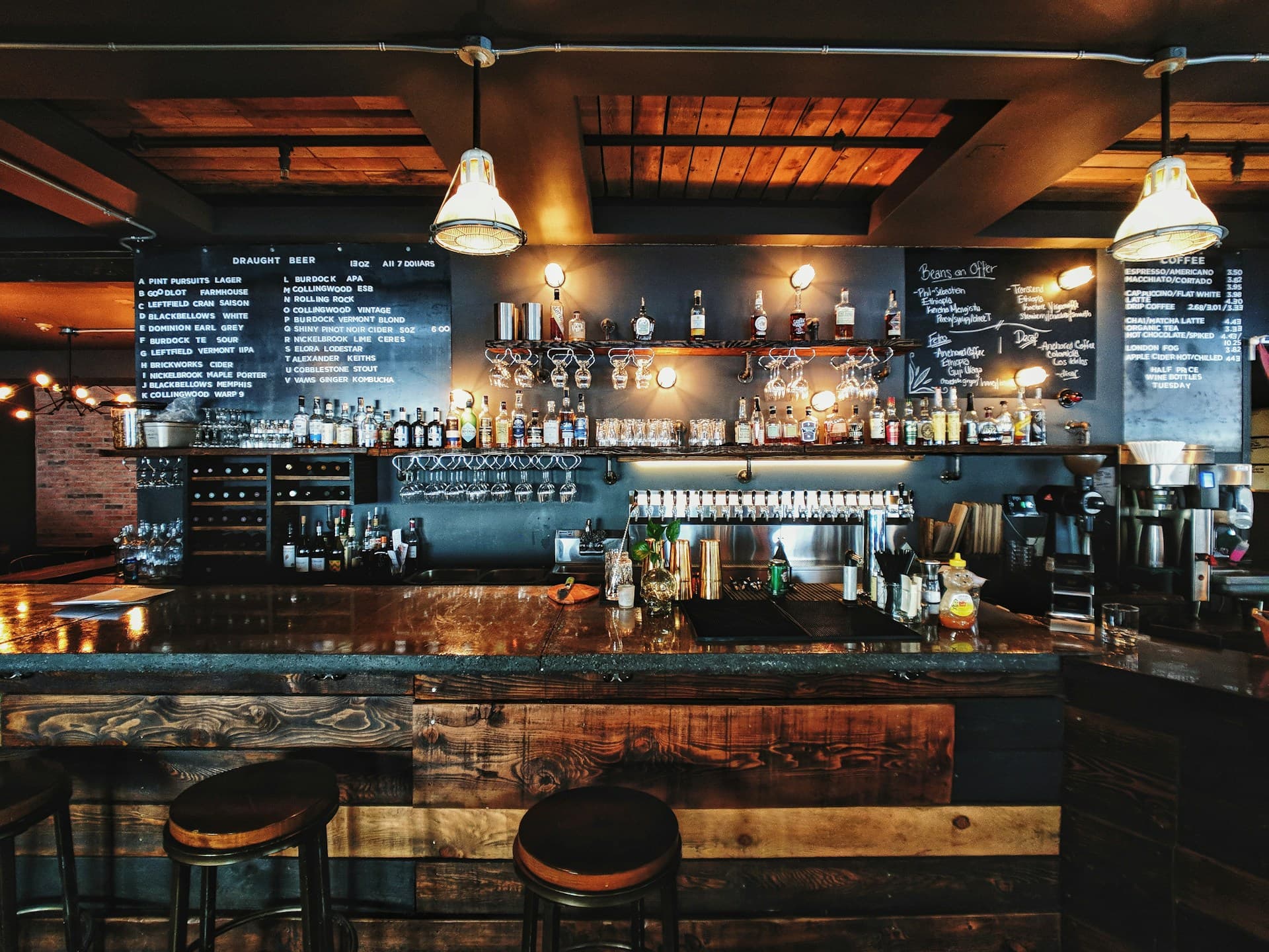 Low-lit cocktail lounge interior with warm amber light over a marble bar